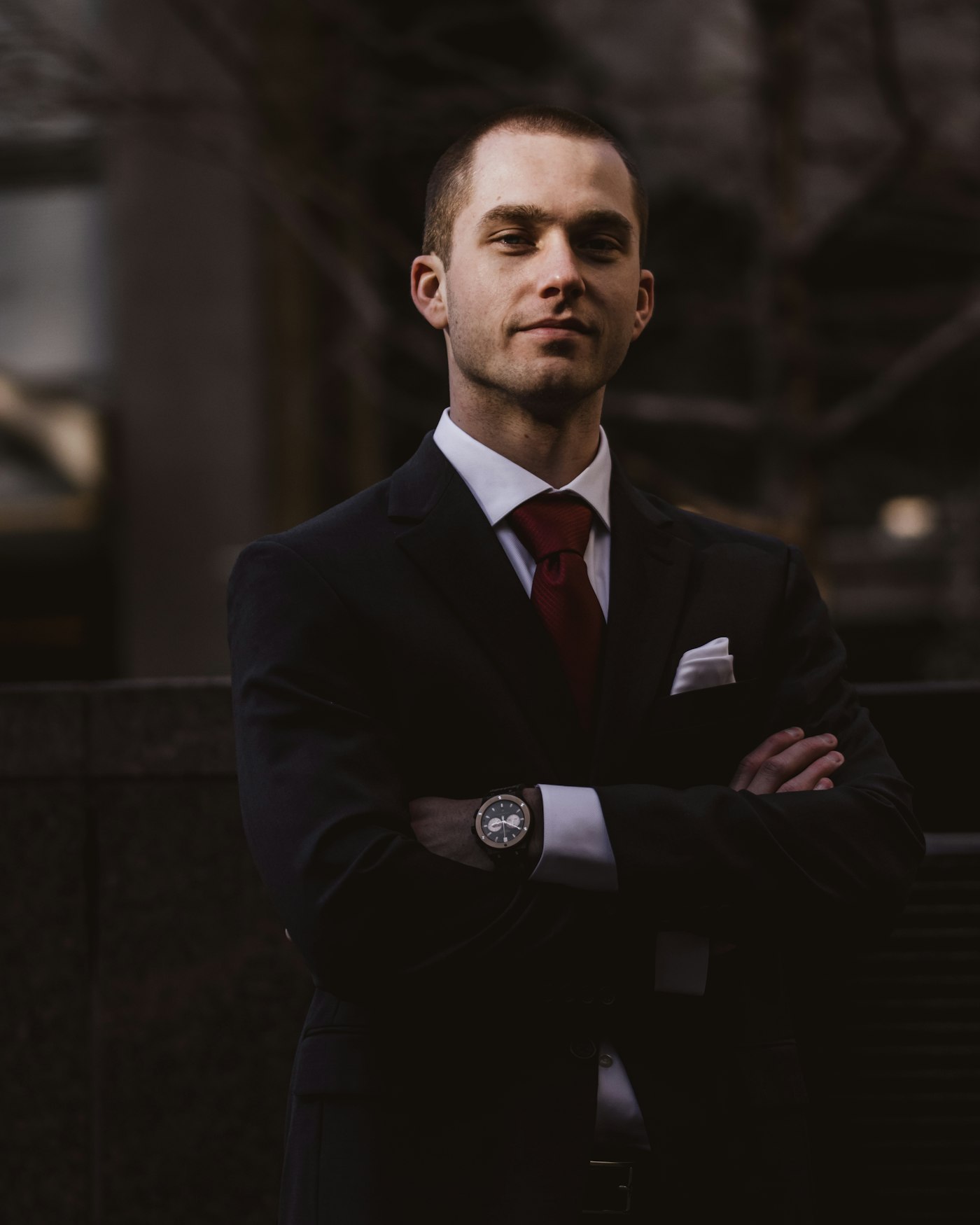Confident accountant in a dark suit standing outside an office building