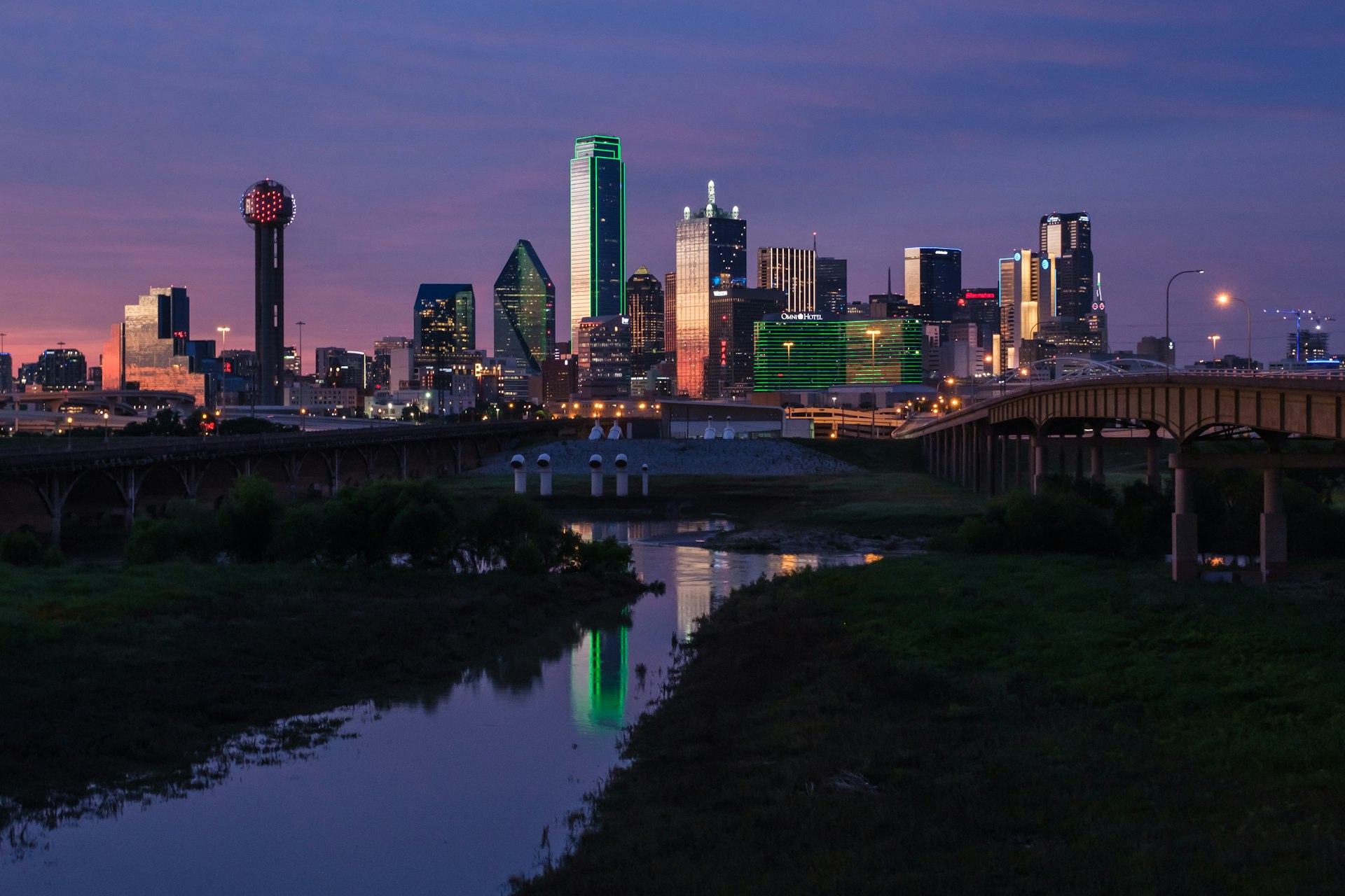 A city skyline at night with illuminated office towers